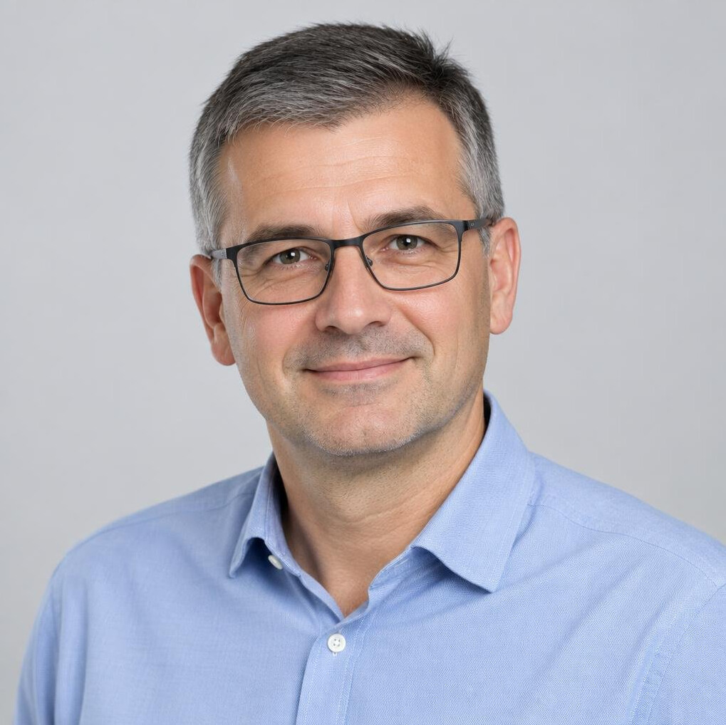 Studio portrait of a Croatian man in his 40s wearing glasses and business casual clothing